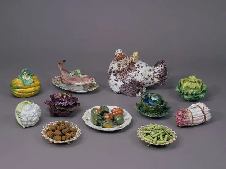 Objects from the Deception exhibition including ceramic vegetables, a turkey and plates of food. All the pieces are artfully created to look as life like as possible.